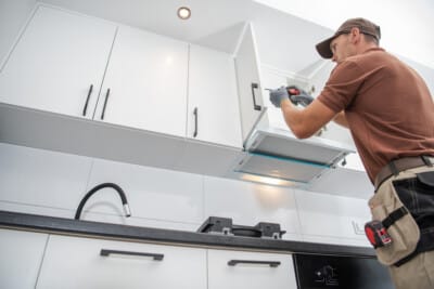 Contractor Worker Assembling of New Apartment Kitchen Cabinets Küchenmonteur